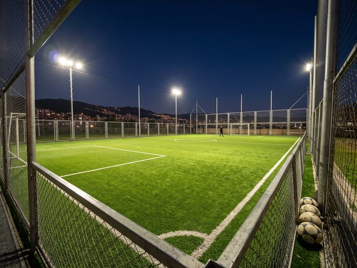 Cancha sintética de noche con luces encendidas